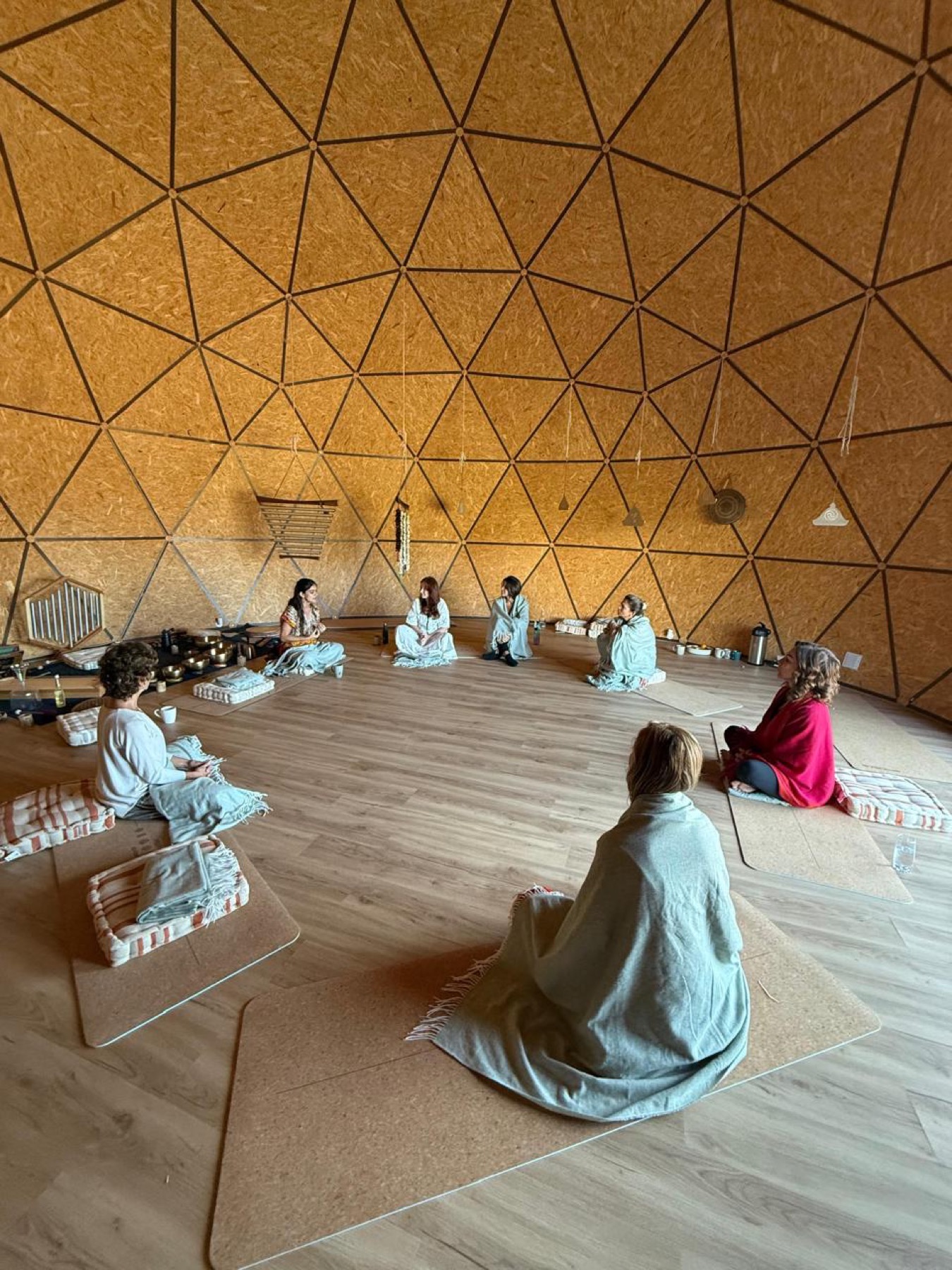 Women held in a circle inside the ceremony dome, wrapped in blankets